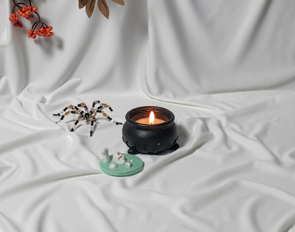 Lumânare parfumată în ceaun de vrăjitoare The Witch's Cauldron pe fundal alb decor Halloween